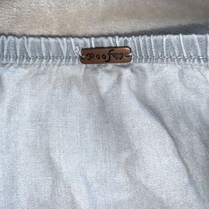 This is a denim blue off the shoulder shirt, size medium, from the brand poof.